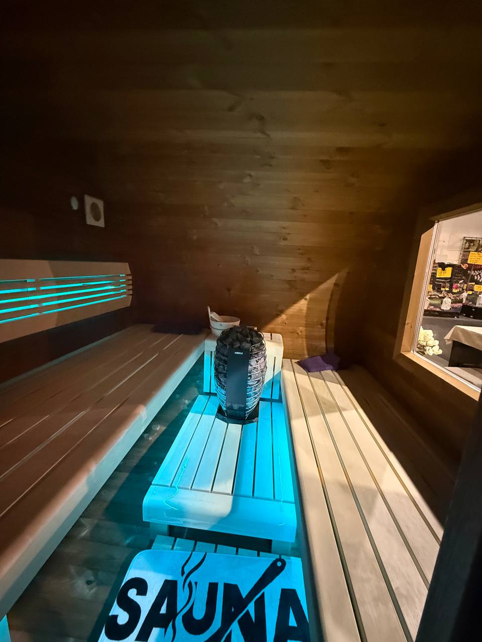 Palkkio Fasssauna Harvia Ofen mit türkiser LED-Beleuchtung