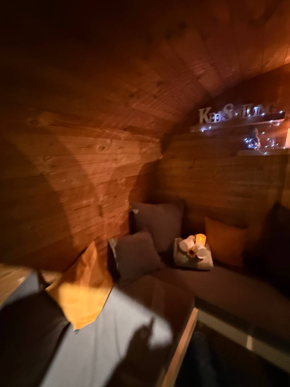 Palkkio Fasssauna Vorraum gemütliche Atmosphäre mit Kissen und Kerzen