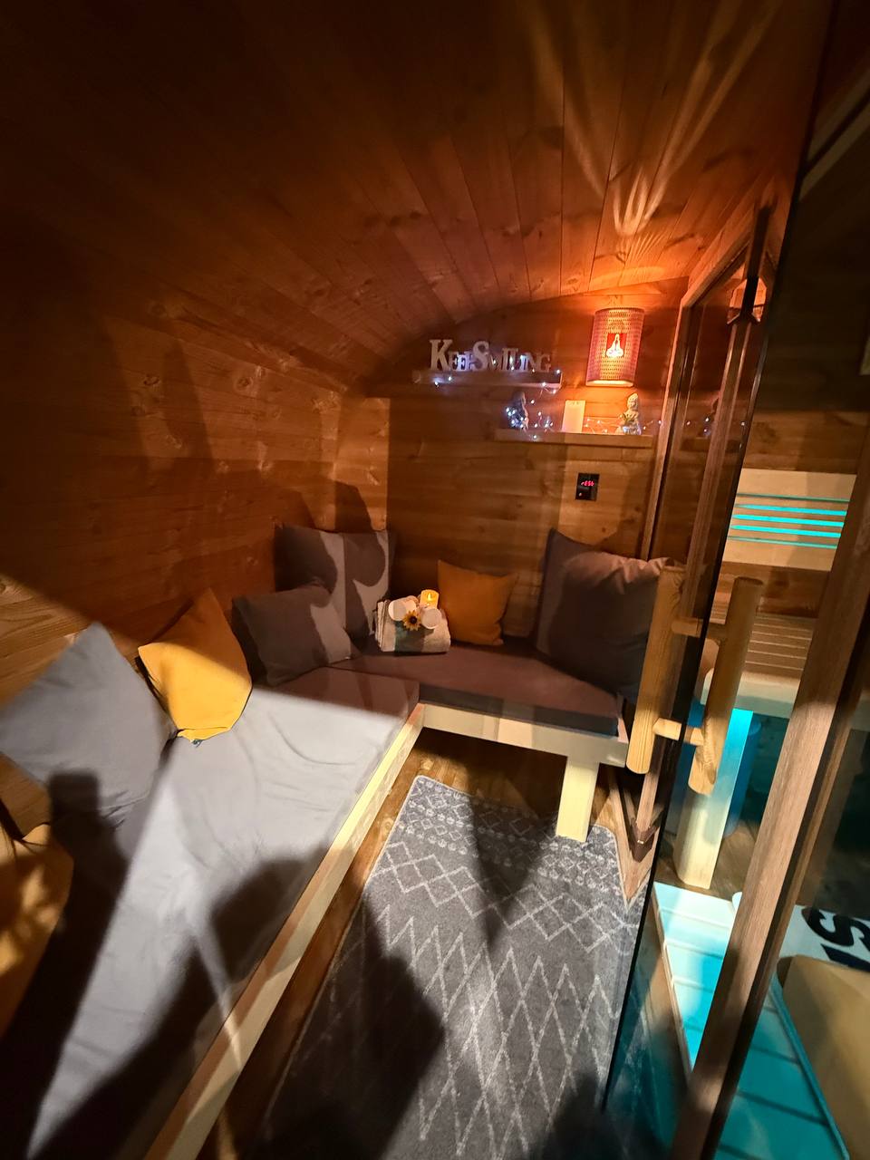 Palkkio Fasssauna Vorraum mit Lounge-Polstern und Deko